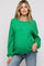 woman wearing a green oversized maternity sweater and showing her baby bump