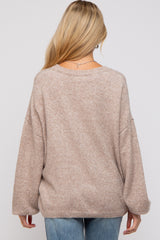 woman wearing a light brown oversized maternity sweater with a relaxed fit and drop shoulder sleeves