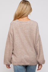 woman wearing a light brown oversized maternity sweater with a relaxed fit and drop shoulder sleeves