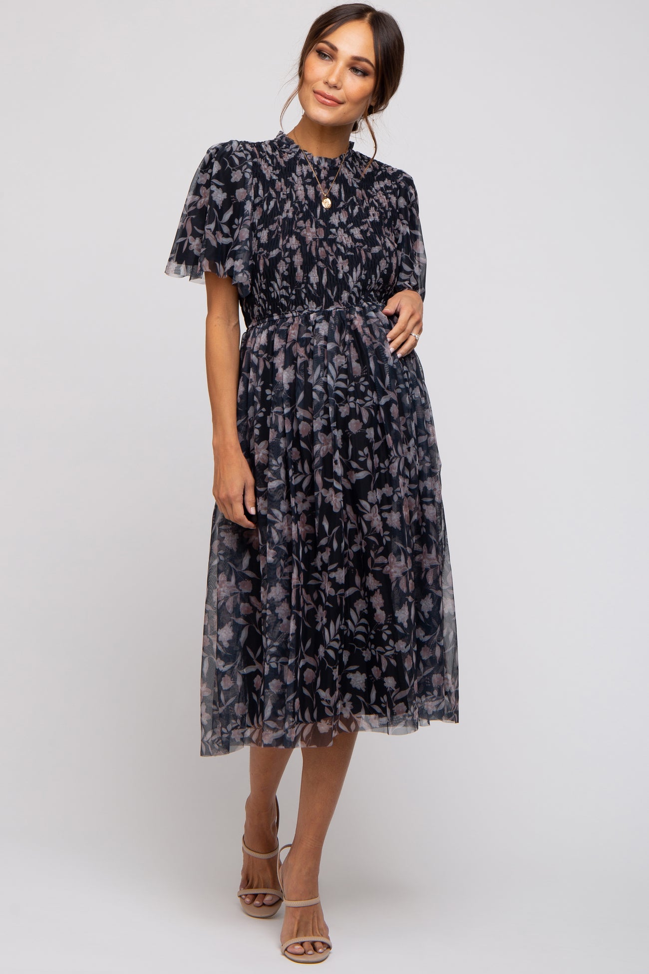 woman wearing a navy blue floral maternity dress with short puff sleeves and a gathered waist