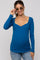 woman wearing a teal long sleeve maternity top with a scoop neckline and a baby bump visible