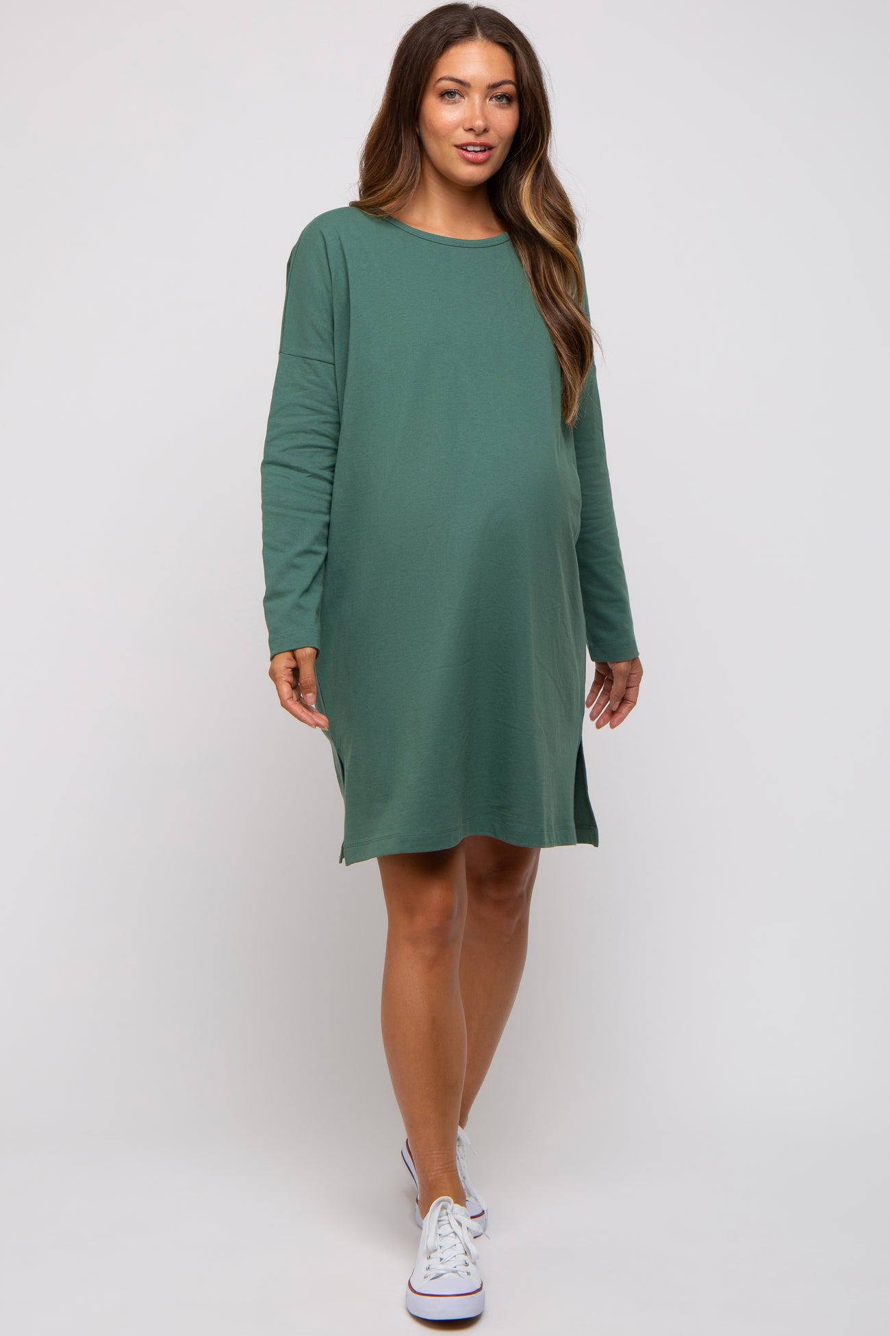 woman wearing a green long sleeve maternity dress with a relaxed fit and a visible baby bump