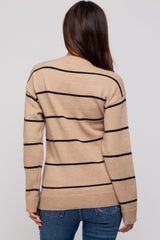 woman wearing a beige striped maternity sweater with black lines, seen from the back