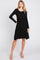 woman wearing a black long sleeve knit dress with a belted waist and flared skirt