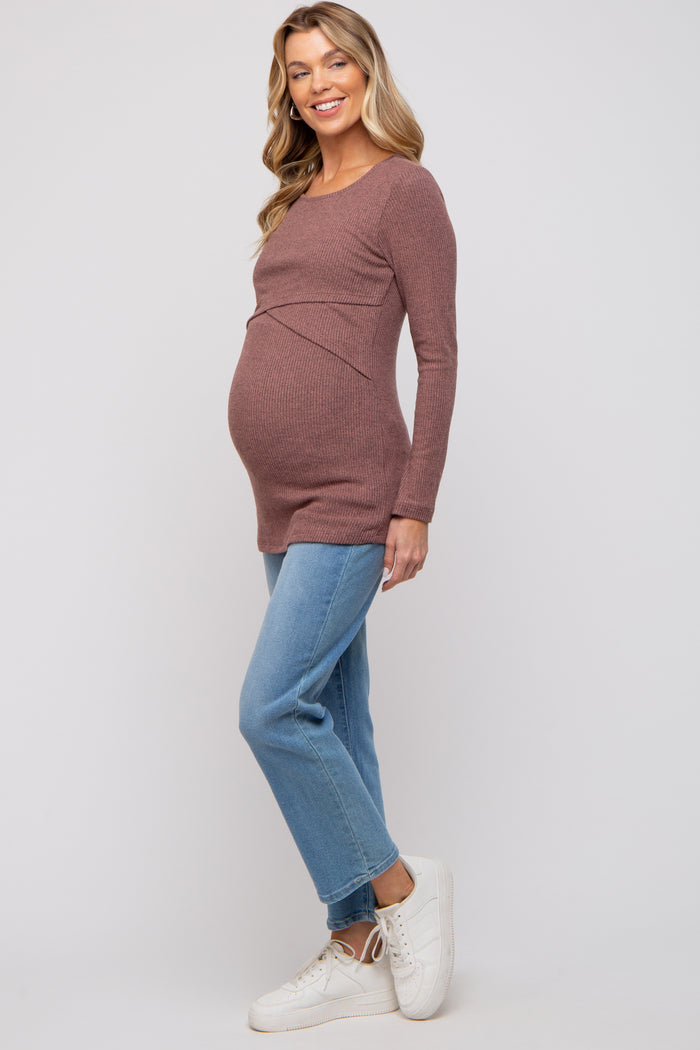 woman wearing a brown ribbed maternity top and blue jeans, showing off her baby bump