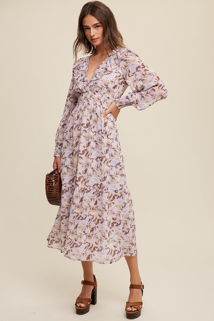 woman wearing a floral print long sleeve wrap dress with a deep V-neck and ruffled details