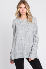 woman wearing a grey speckled oversized sweater with long sleeves and a relaxed fit