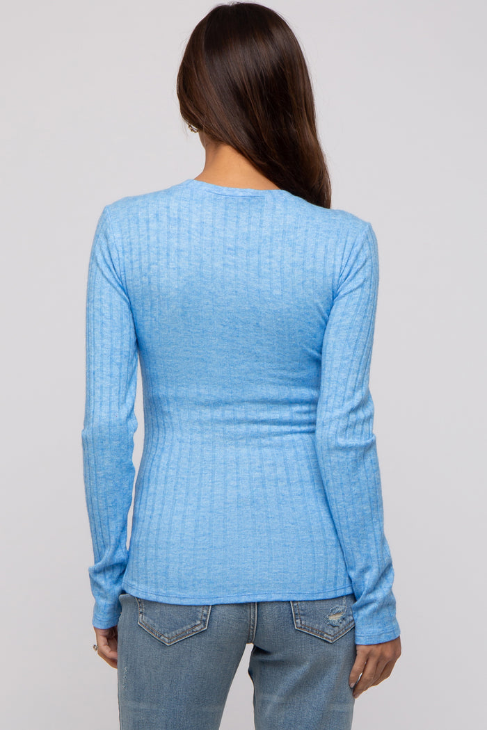 woman wearing a light blue long sleeve maternity top, viewed from the back, styled with a ribbed texture