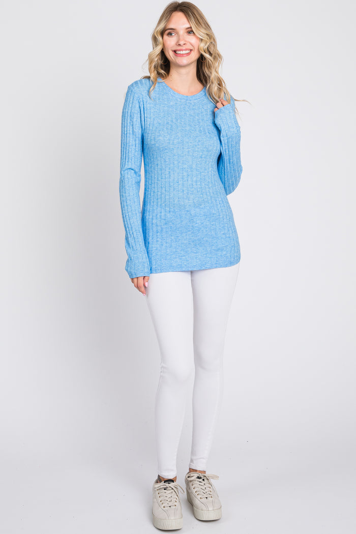 woman wearing a light blue ribbed long sleeve sweater with white skinny jeans and sneakers