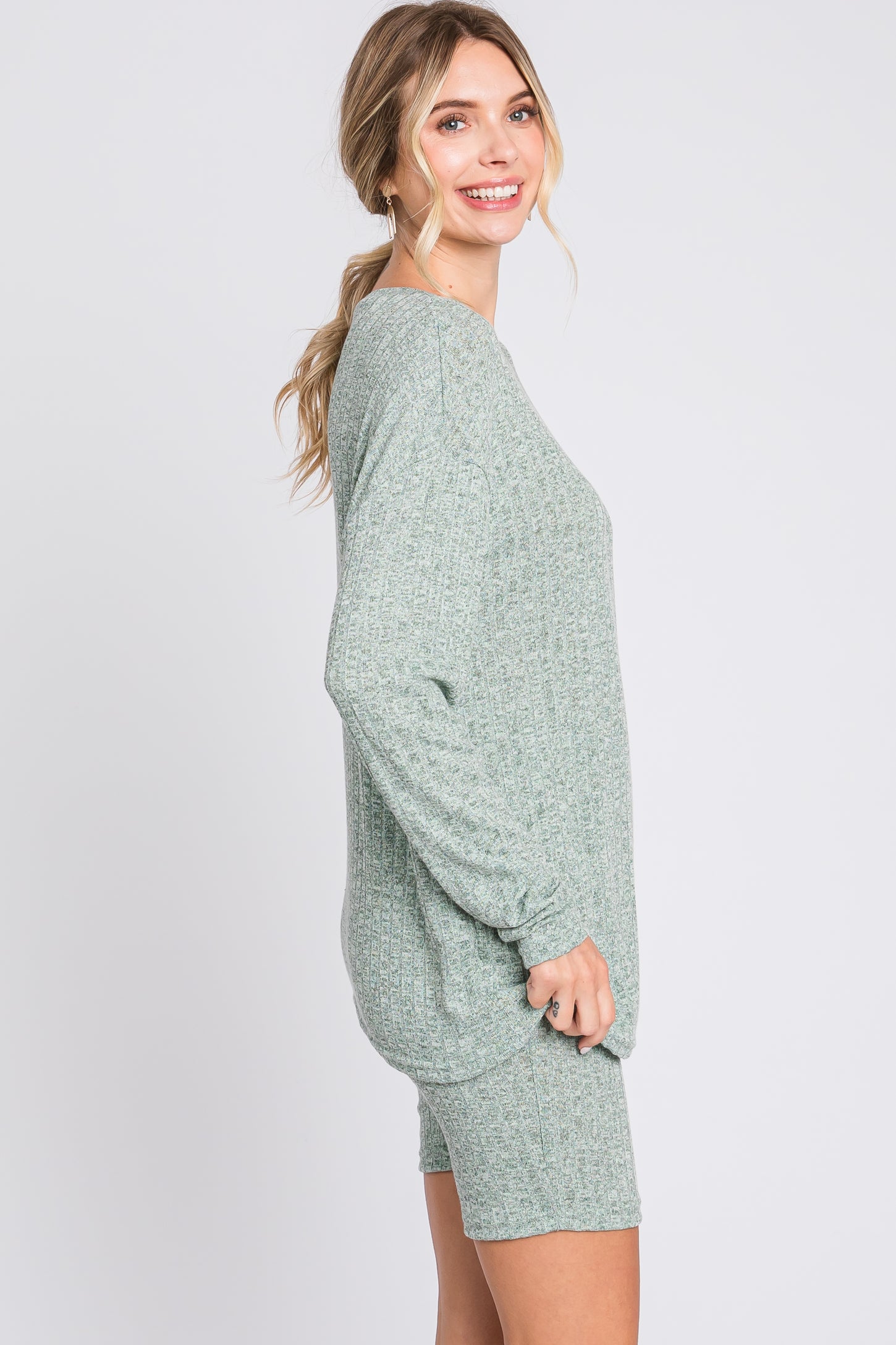 woman wearing a green oversized lounge set with long sleeve top and matching shorts