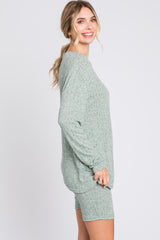 woman wearing a green oversized lounge set with long sleeve top and matching shorts