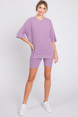 woman wearing a lilac ribbed short sleeve top and matching shorts with a relaxed fit and white sneakers