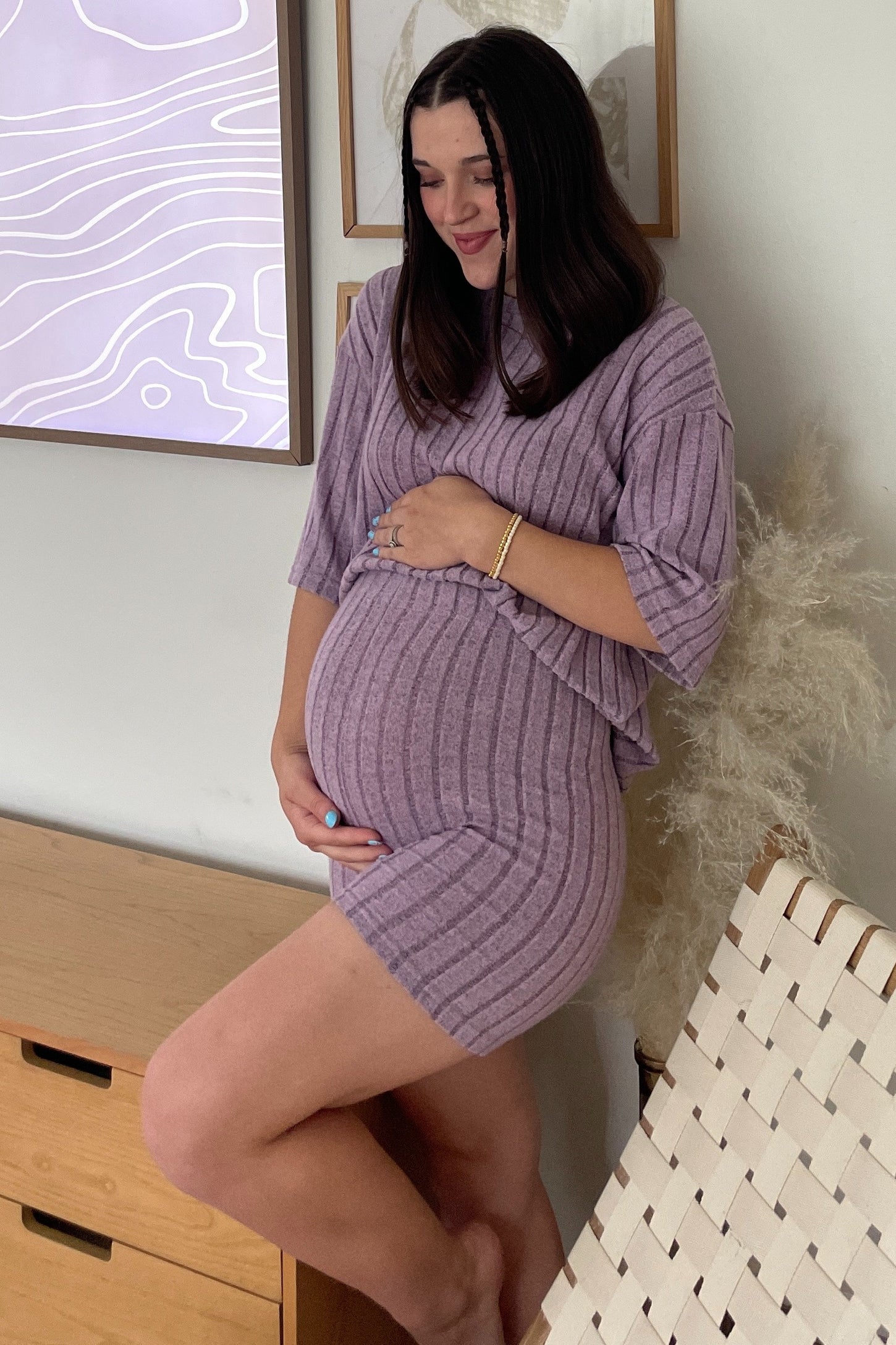woman wearing a lavender ribbed maternity dress with short sleeves and a visible baby bump