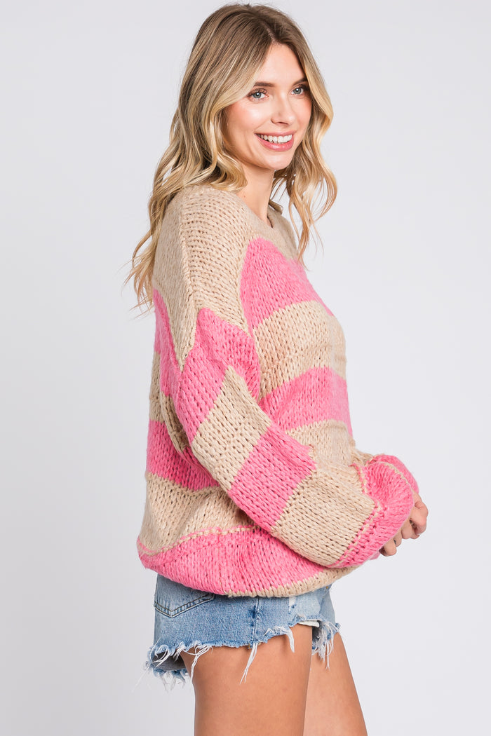 woman wearing a beige and pink striped oversized sweater with long sleeves and denim shorts