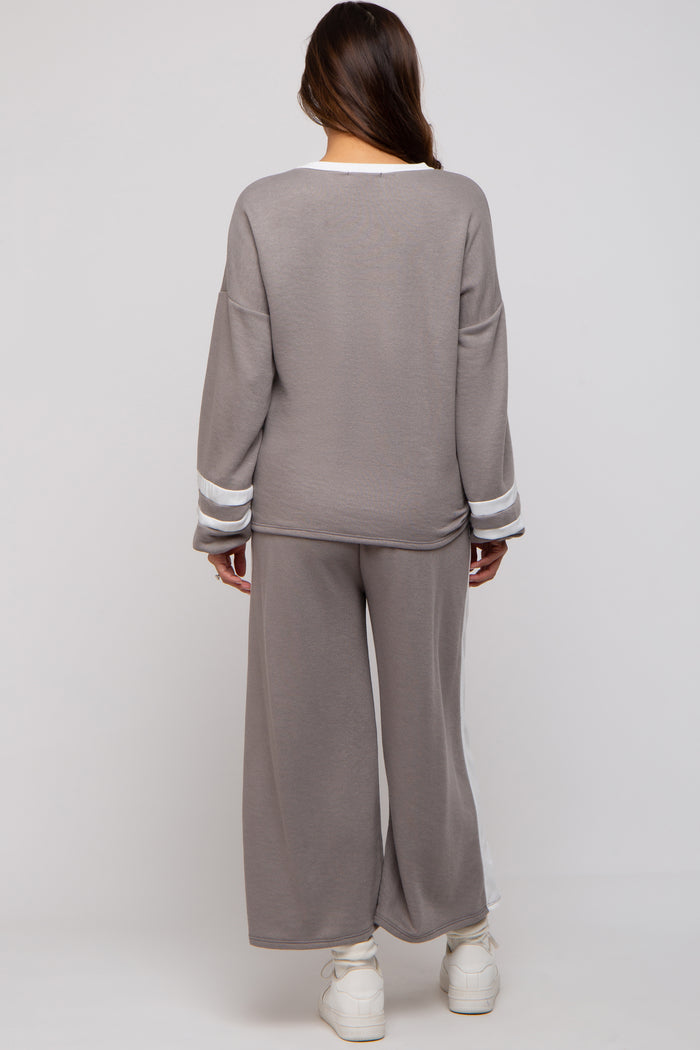 woman wearing a gray maternity loungewear set with white stripe details, showing a relaxed fit from the back