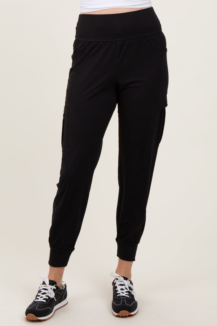 woman wearing black jogger pants with side pockets and cuffed ankles, paired with black sneakers