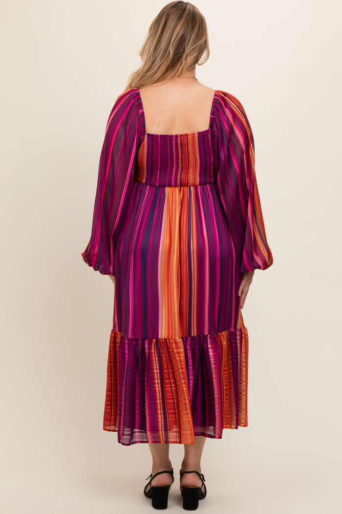 woman wearing a colorful striped maternity plus dress with puff sleeves and a ruffled hem, showing her back