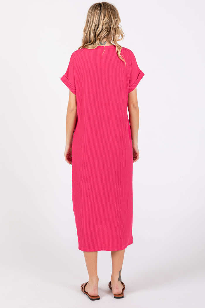 woman wearing a bright pink short sleeve maxi dress, viewed from the back