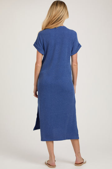 woman wearing a long blue striped maternity dress with short sleeves and a knee-high side slit seen from the back