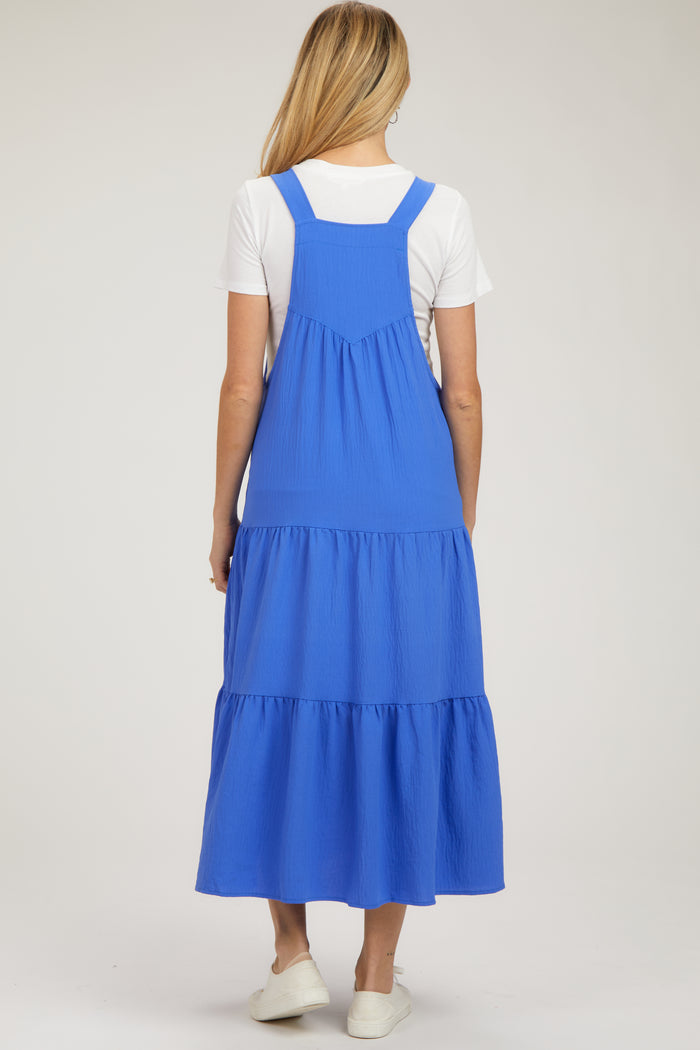 woman wearing a blue tiered maternity dress with adjustable straps and a flowing skirt