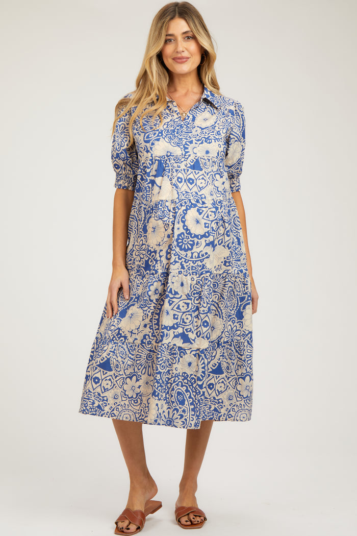 woman wearing a blue and cream patterned maternity dress with short puff sleeves and a midi length