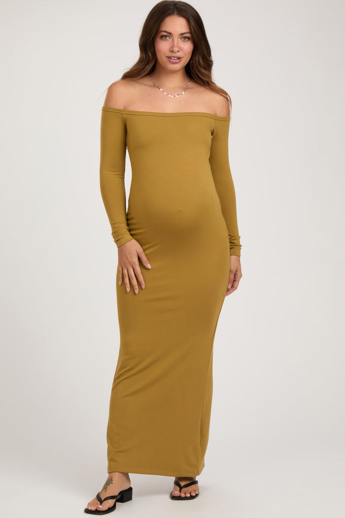 woman wearing a mustard off-the-shoulder maternity maxi dress and showing her baby bump