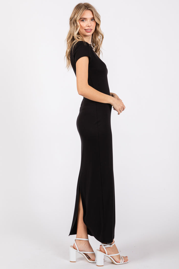 woman wearing a black short sleeve maxi dress with a side slit and white strappy heels