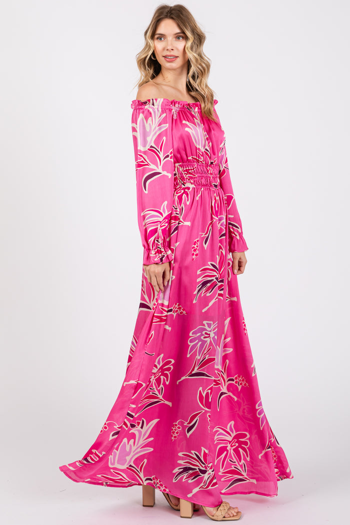 woman wearing a pink floral off-the-shoulder maxi dress with long sleeves and smocked waist