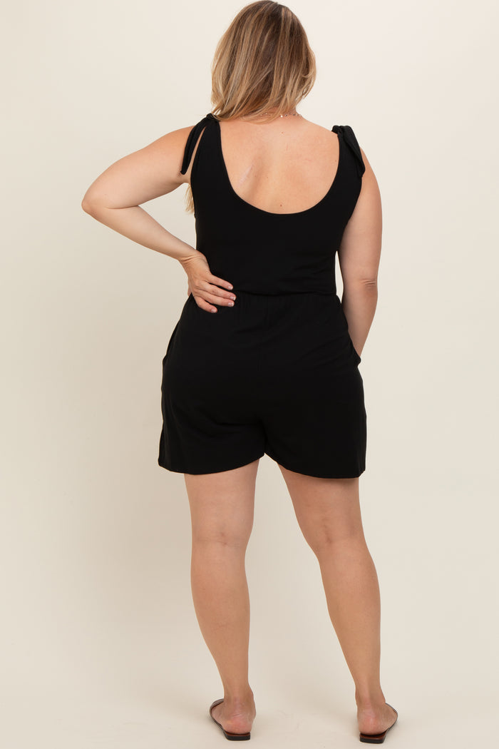 woman wearing a black maternity plus romper with tie straps, showing the back and a relaxed fit