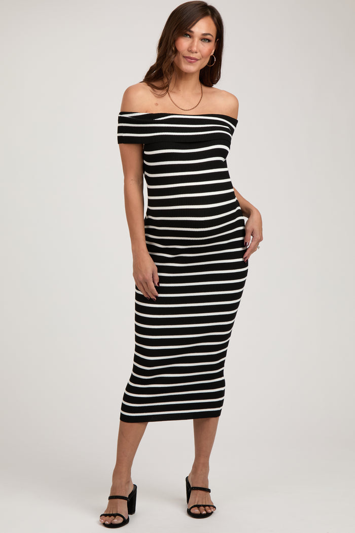woman wearing a black and white striped off-the-shoulder maternity dress fitted to highlight her baby bump