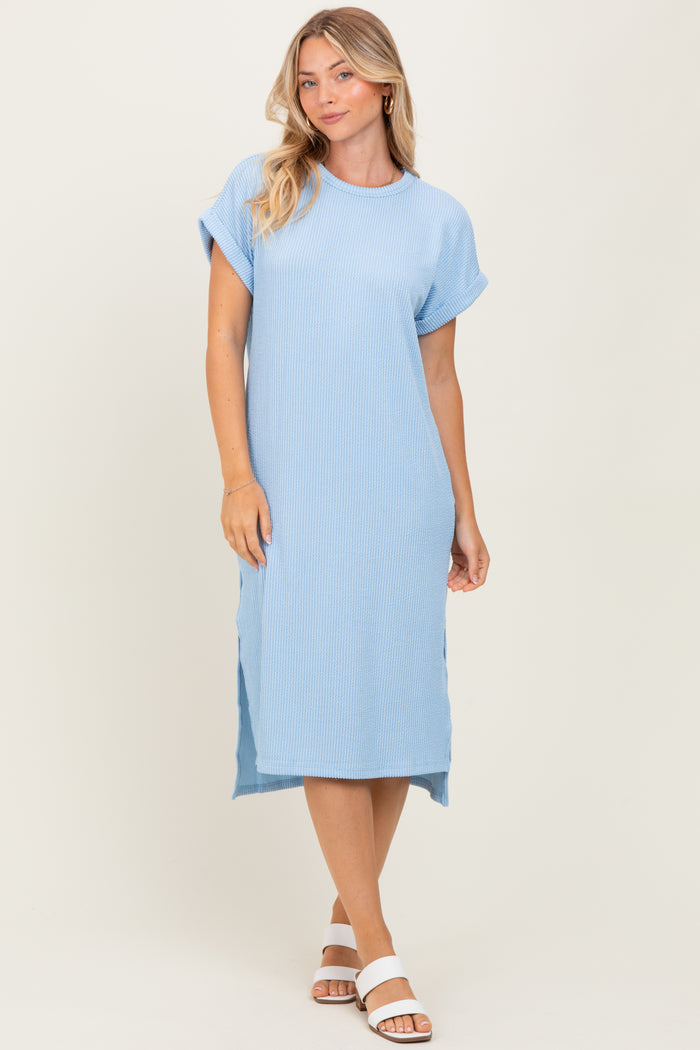 woman wearing a light blue relaxed fit ribbed midi dress with rolled sleeves and side slits