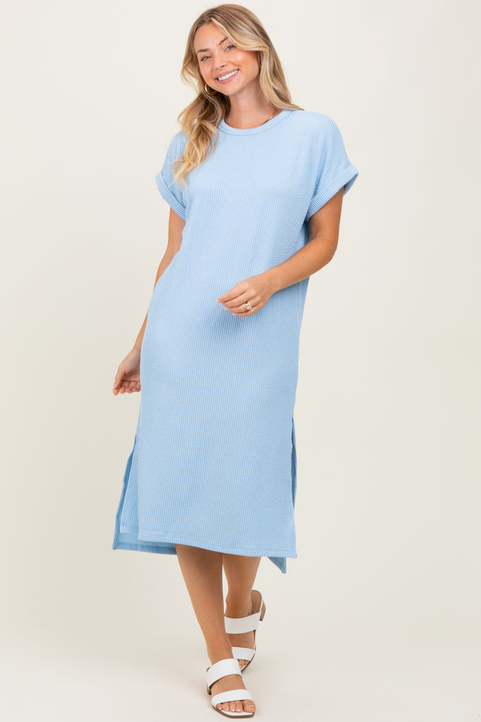 woman wearing a light blue ribbed midi dress with short sleeves and side slits
