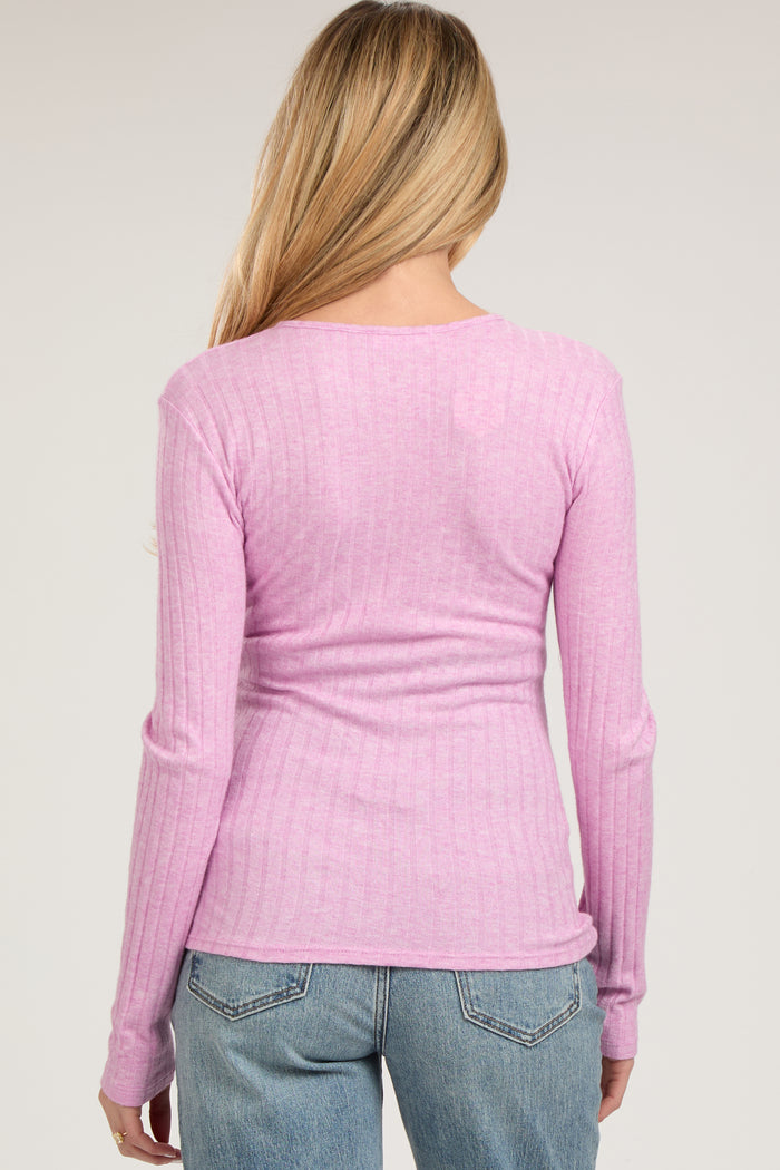 woman wearing a light pink ribbed long sleeve maternity top, seen from the back
