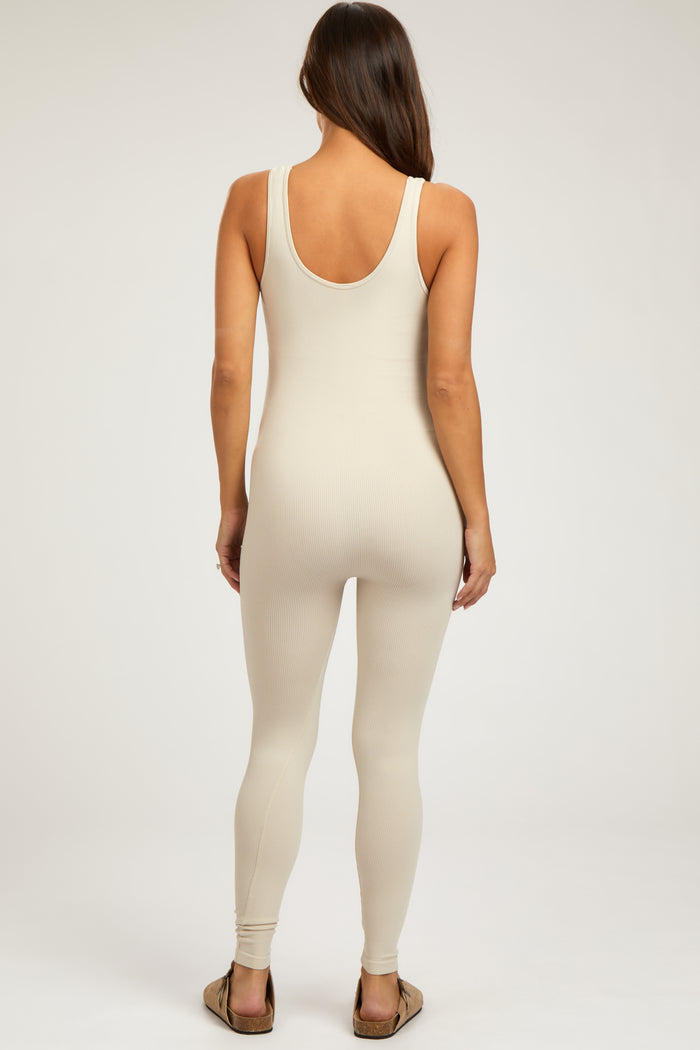 woman wearing a beige ribbed maternity jumpsuit with a scoop back and form-fitting design