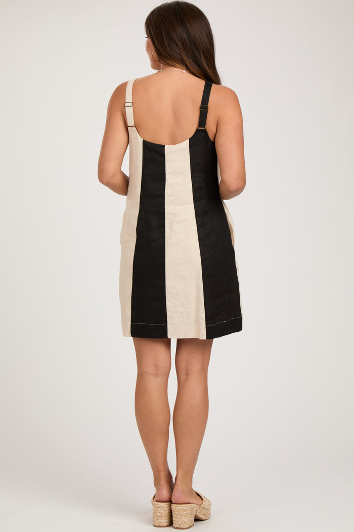 woman wearing a black and beige striped maternity dress with adjustable straps, showing her back