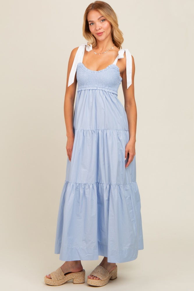 woman wearing a light blue tiered maxi dress with smocked bodice and tie shoulder straps