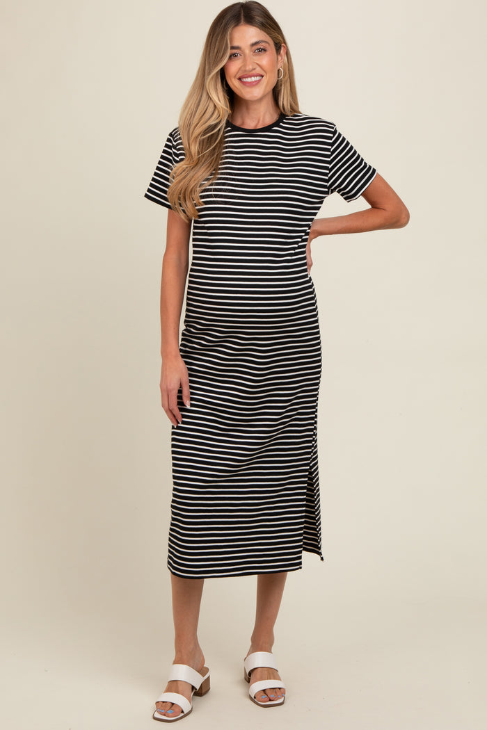 woman wearing a black and white striped maternity dress with short sleeves and a side slit, revealing her baby bump