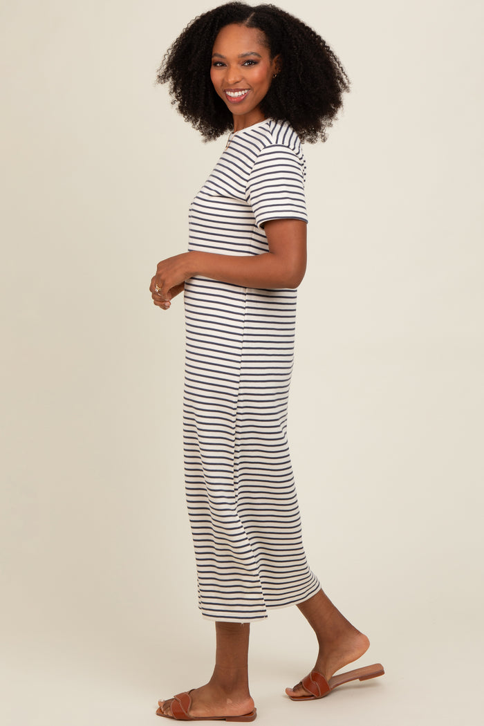 woman wearing a striped midi dress with short sleeves and side slits, styled with flat sandals