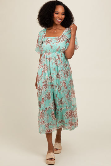 woman wearing a mint green floral maxi dress with short flutter sleeves and a square neckline