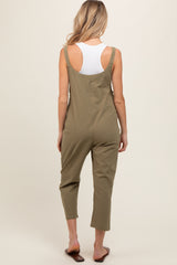 woman wearing an olive green maternity jumpsuit with adjustable straps and cropped legs, showing her back
