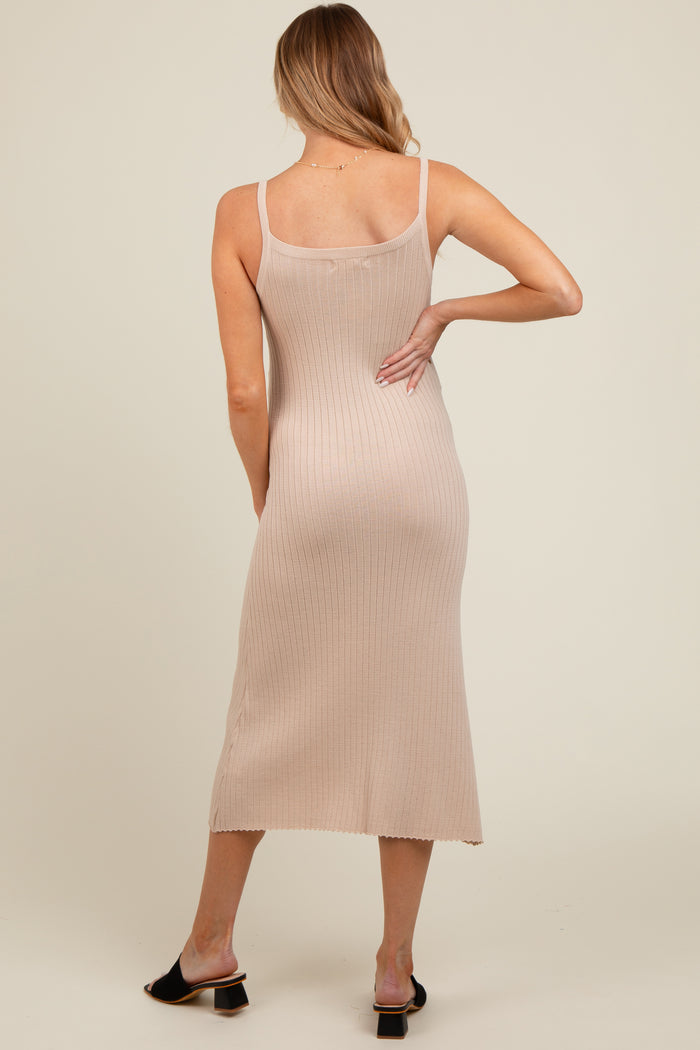 woman wearing a beige ribbed maternity midi dress with a fitted silhouette and spaghetti straps viewed from the back