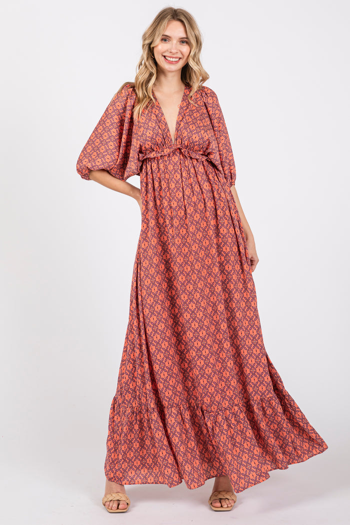 woman wearing a long maroon floral maxi dress with puff sleeves and a tie front detail