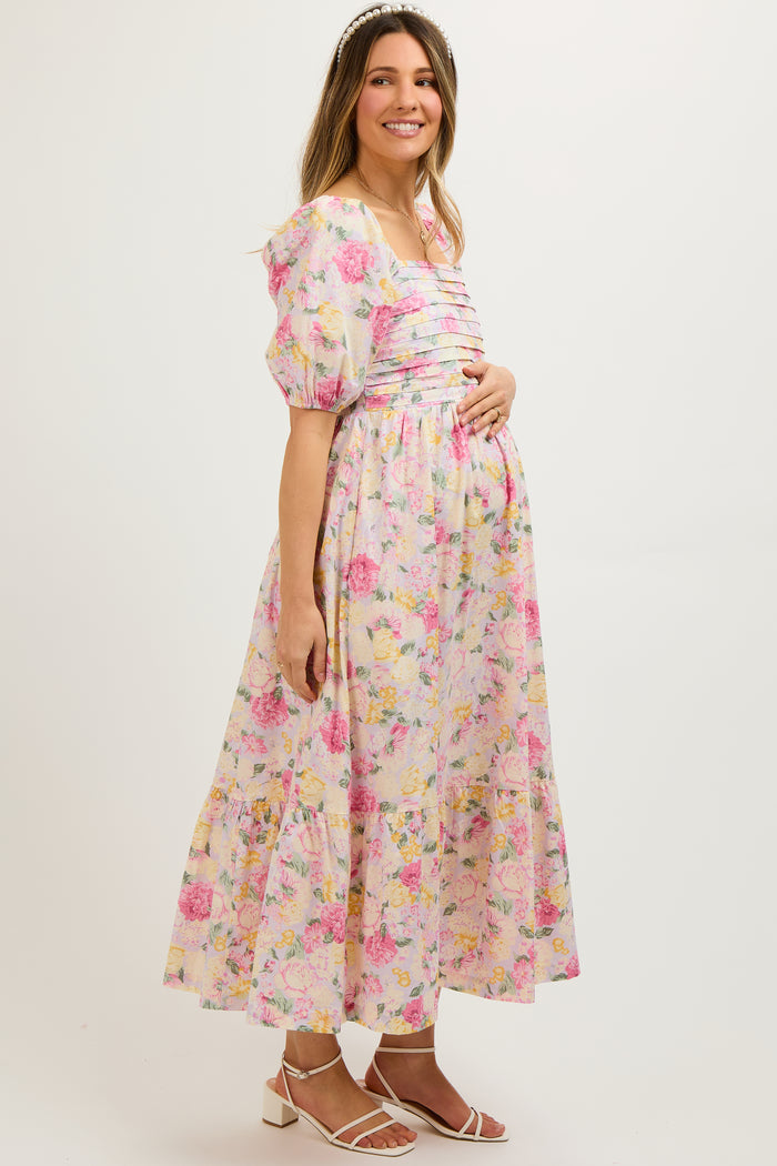 woman wearing a pink floral maternity dress with puff sleeves and a baby bump