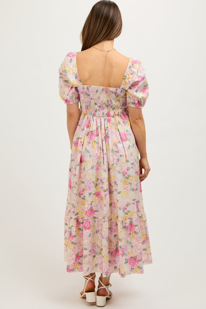 woman wearing a floral maternity maxi dress with puff sleeves and a smocked back, showing her baby bump