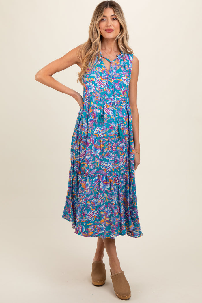 woman wearing a vibrant floral print sleeveless maternity dress with a tiered skirt and a keyhole neckline