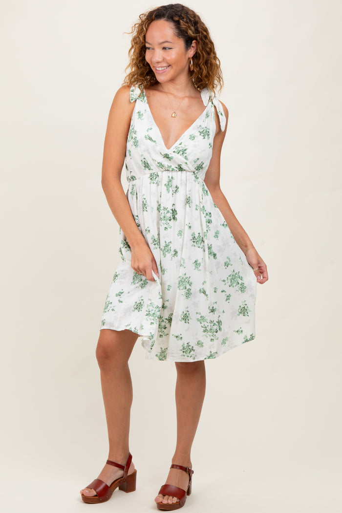 woman wearing a white floral print dress with tie straps and a flattering v-neckline
