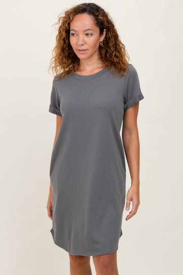 woman wearing a gray short sleeve t-shirt dress with rolled sleeves and a relaxed fit