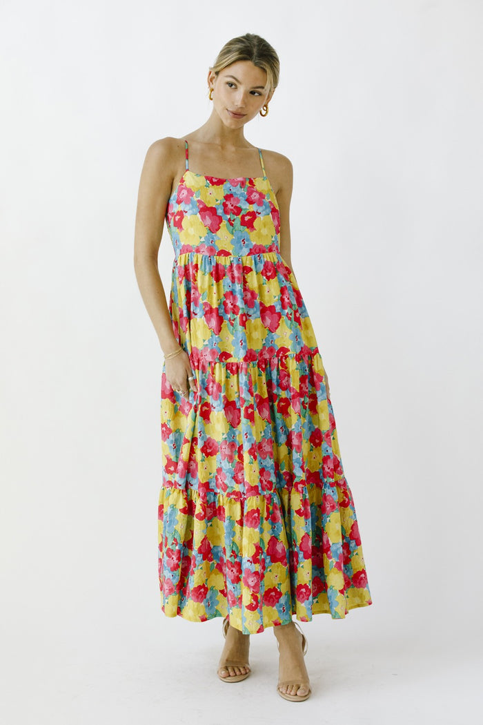 woman wearing a colorful floral maxi dress with tiered layers and spaghetti straps