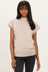 woman wearing a beige short sleeve ribbed mock neck top paired with black jeans