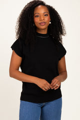 woman wearing a black short sleeve sweater with a mock neck and relaxed fit, paired with blue jeans